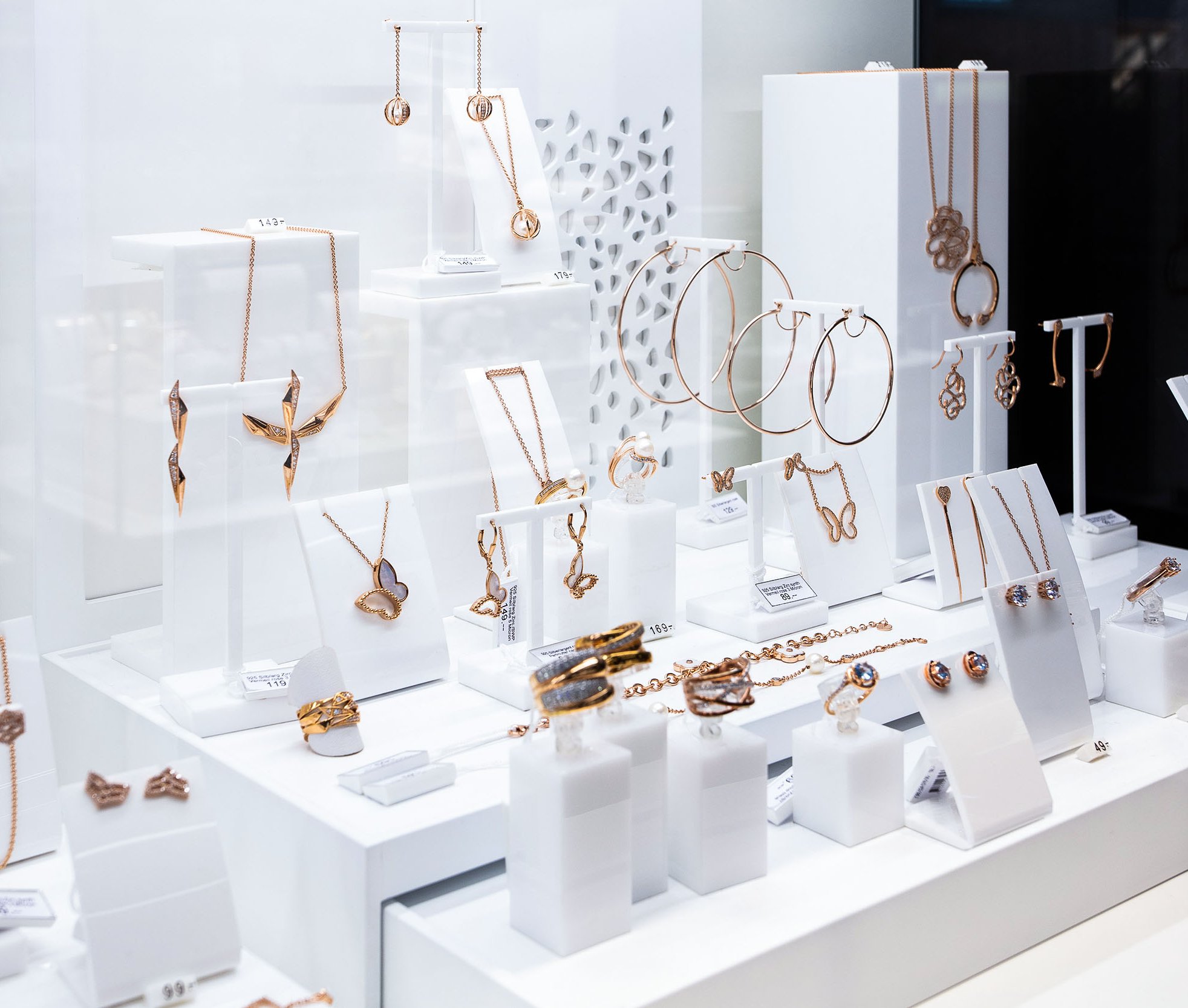 Klassische Umsetzung eines Schmuckdisplays mit unterschiedlichen Einzelaufstellern für Schmuckstücke. Materialmix aus Holz lackiert und farbigem Plexiglas.