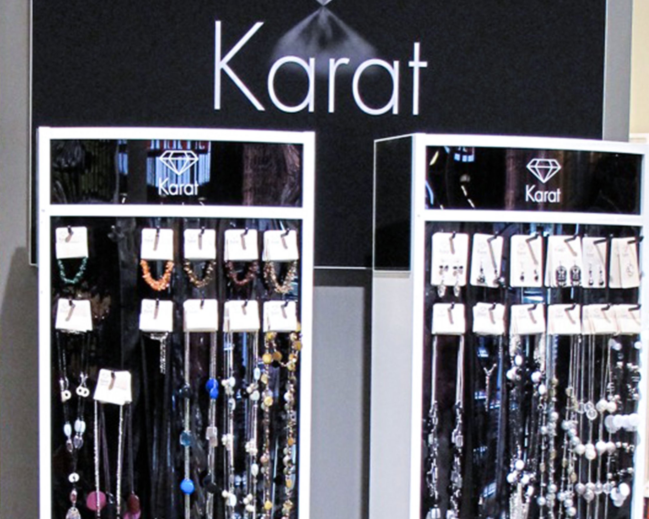 Modeschmuck wir sehr zweckmäßig und elegant auf diesem Displayständer präsentiert. Materialkombination aus weiß glänzendem Holz und gelochtem schwarzen Plexiglas.