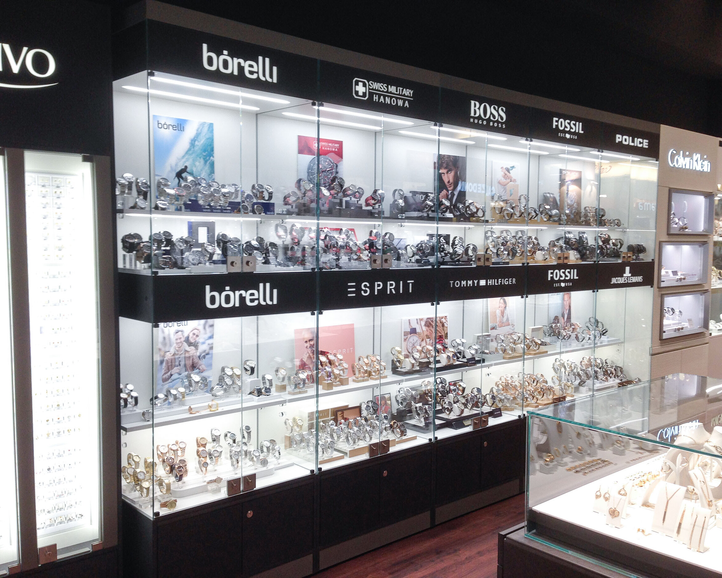 Uhrenvitrinen im Retail. Homogene Präsentation verschiedener Uhrenmarken eines Juweliergeschäfts an einer Wand.