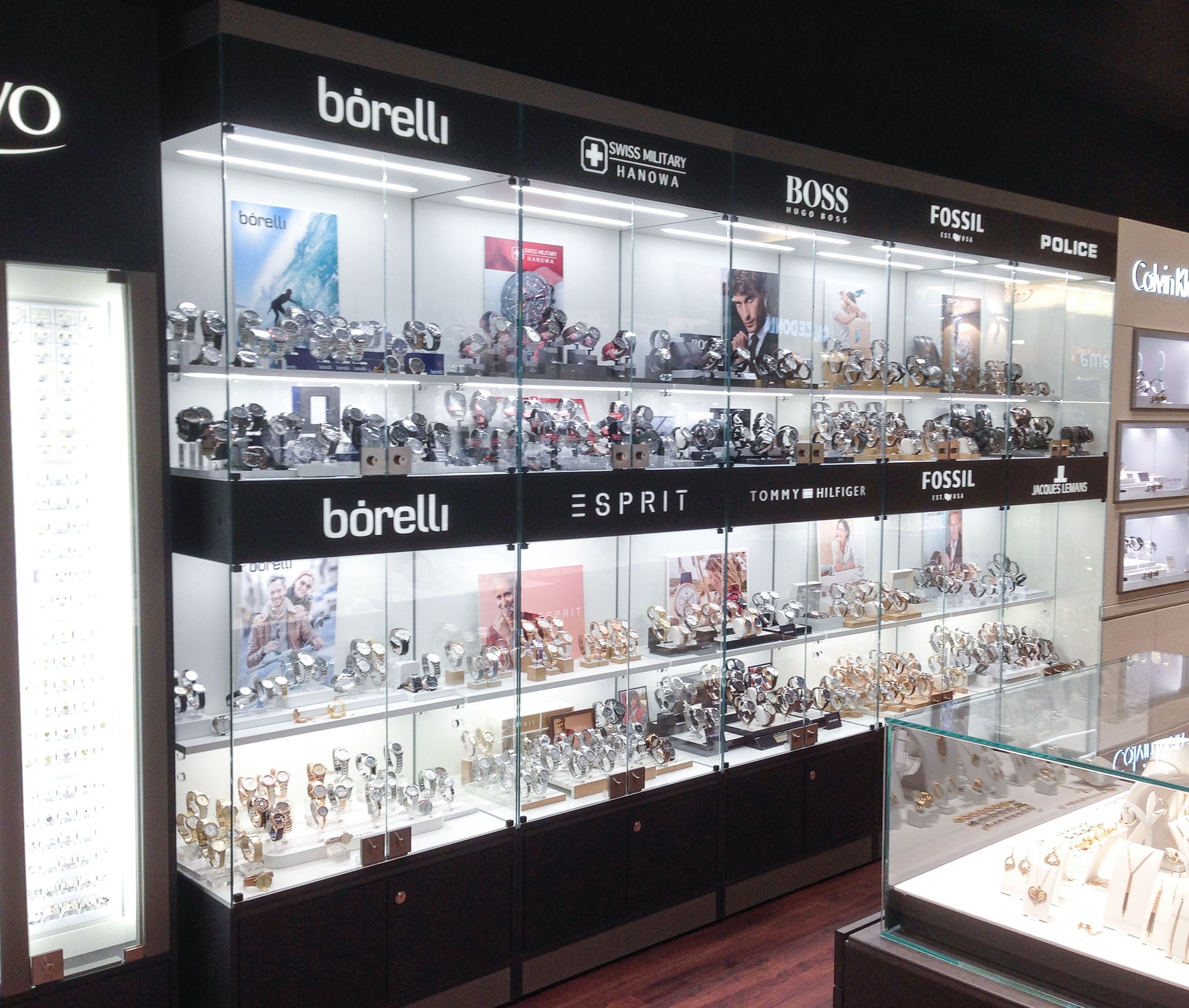 Uhrenvitrinen im Retail. Homogene Präsentation verschiedener Uhrenmarken eines Juweliergeschäfts an einer Wand.